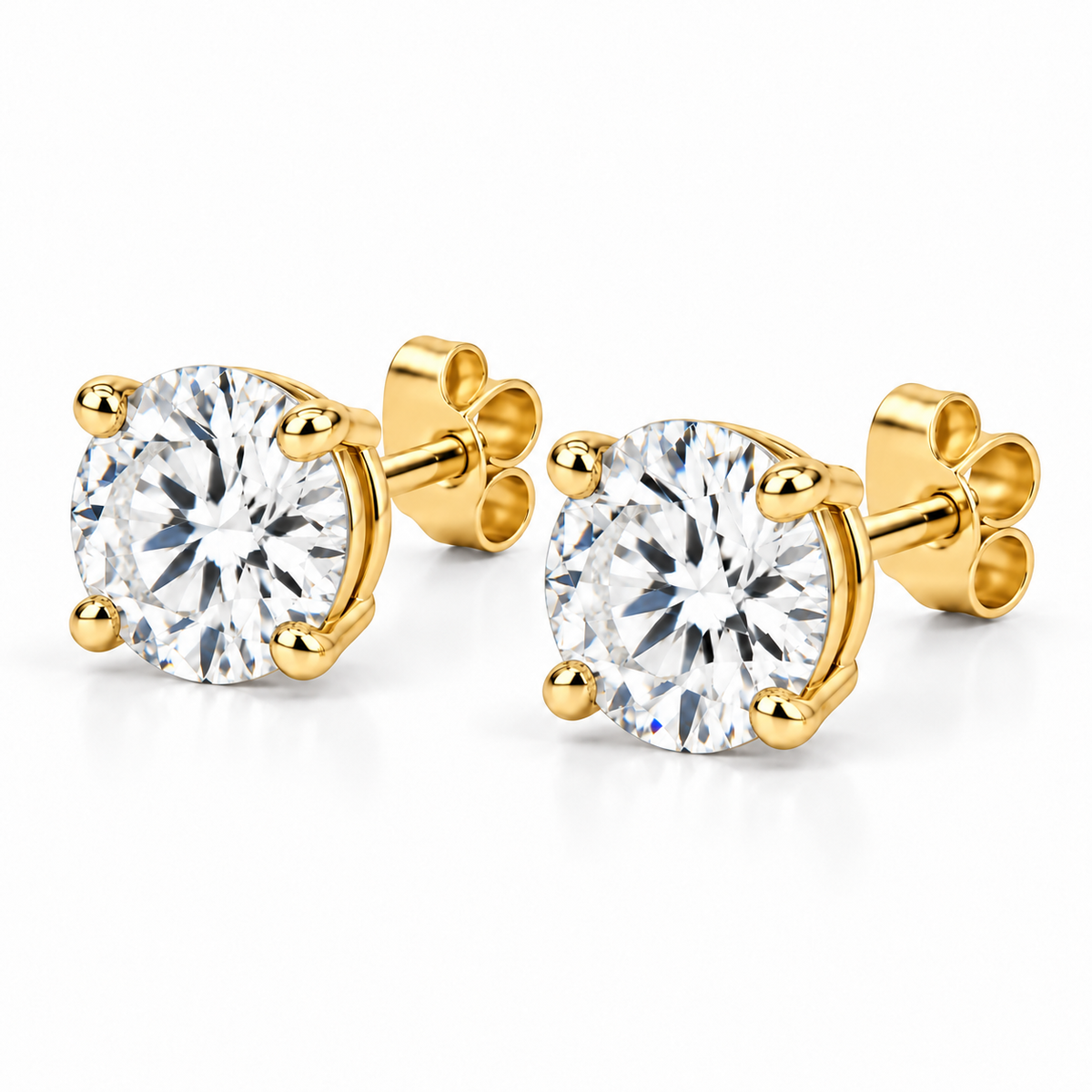 Angled view of lab-grown round diamond stud earrings in 14k yellow gold with four-prong settings and push backs